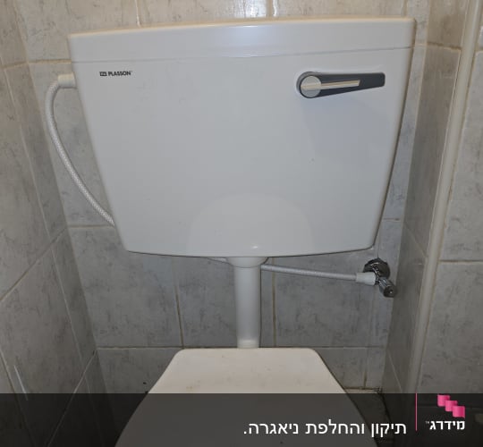 אסלה עם מיכל הדחה בחדר אמבטיה